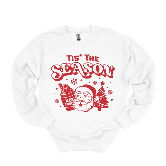 Tis the season Christmas graphic sweatshirt with a graphic featuring pictures of Santa , hot chocolate , and a Christmas tree. Cherry red Christmas graphic on a Snow White soft lined crewneck. Available in long sleeve for kids for matching fit. 